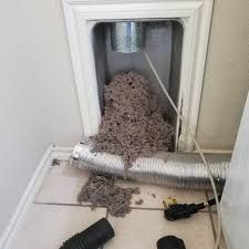 Laundry room lint trap overflowing with gray lint, duct work.