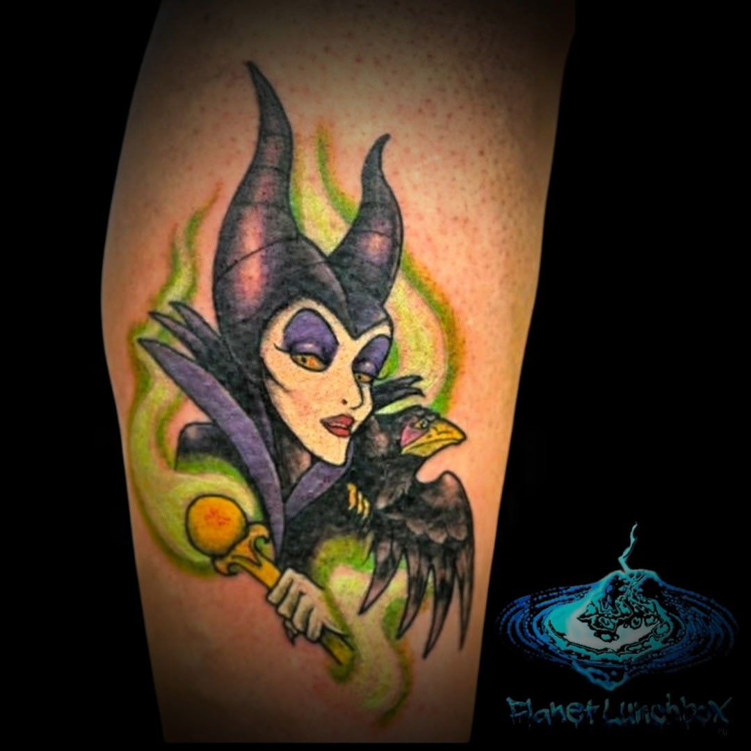 Tattoo of Maleficent in purple and black, with green flames and a raven on her hand