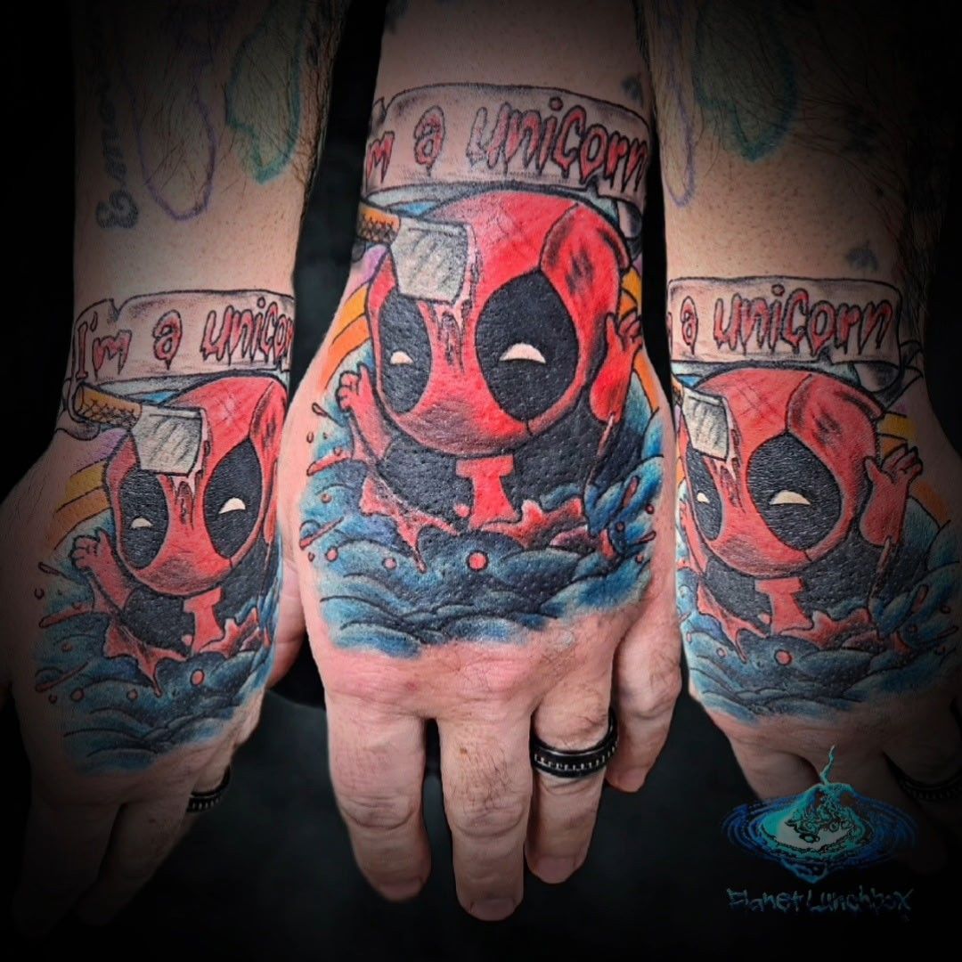 Three Deadpool-themed hand tattoos in red and black, centered on a hand and wrists