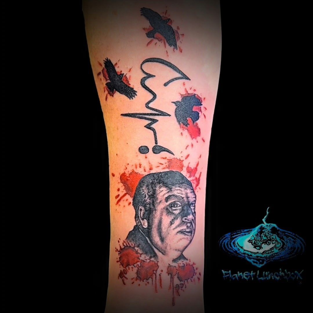Lower leg tattoo with ECG line, splashes of red and black, and a grayscale portrait of a man