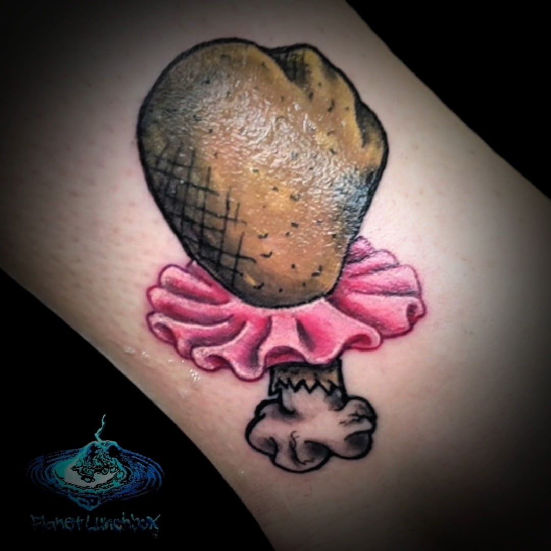 Heart-shaped pastry tattoo with pink ruffled icing on skin