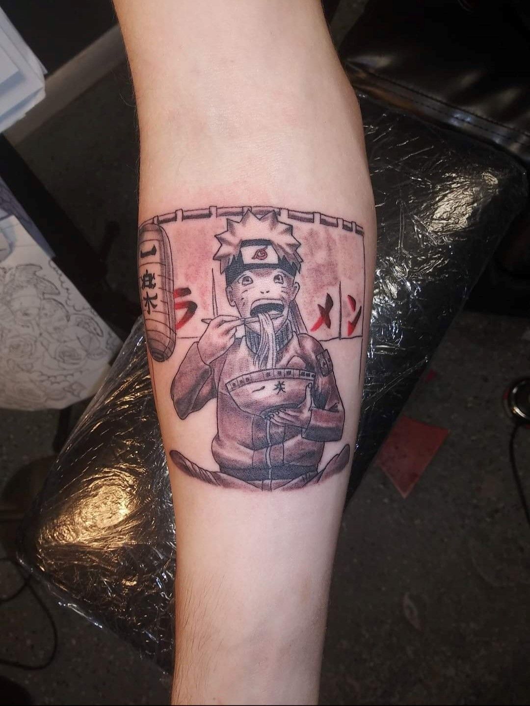 A person has a tattoo of naruto eating ramen
