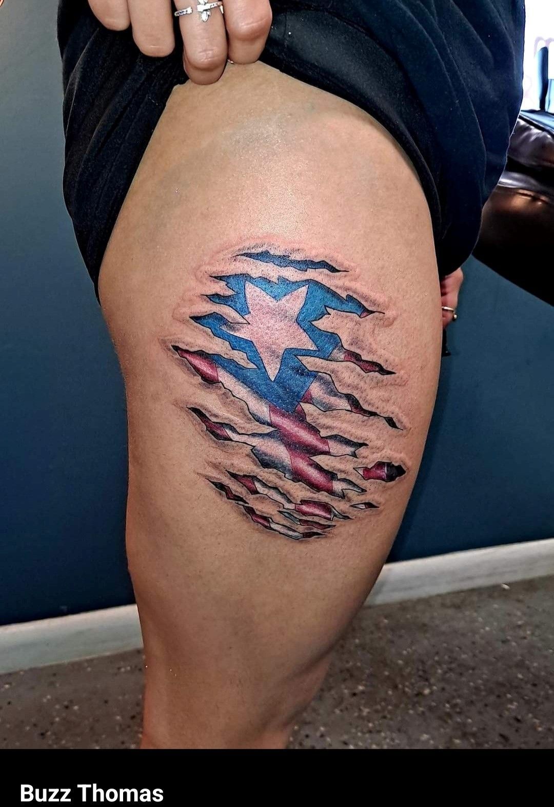 A woman has a tattoo of an american flag on her thigh