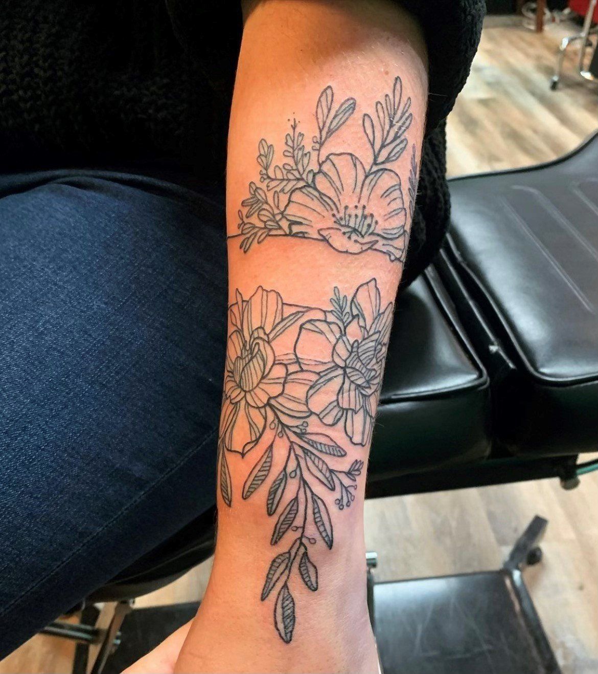 A woman has a tattoo of flowers on her arm