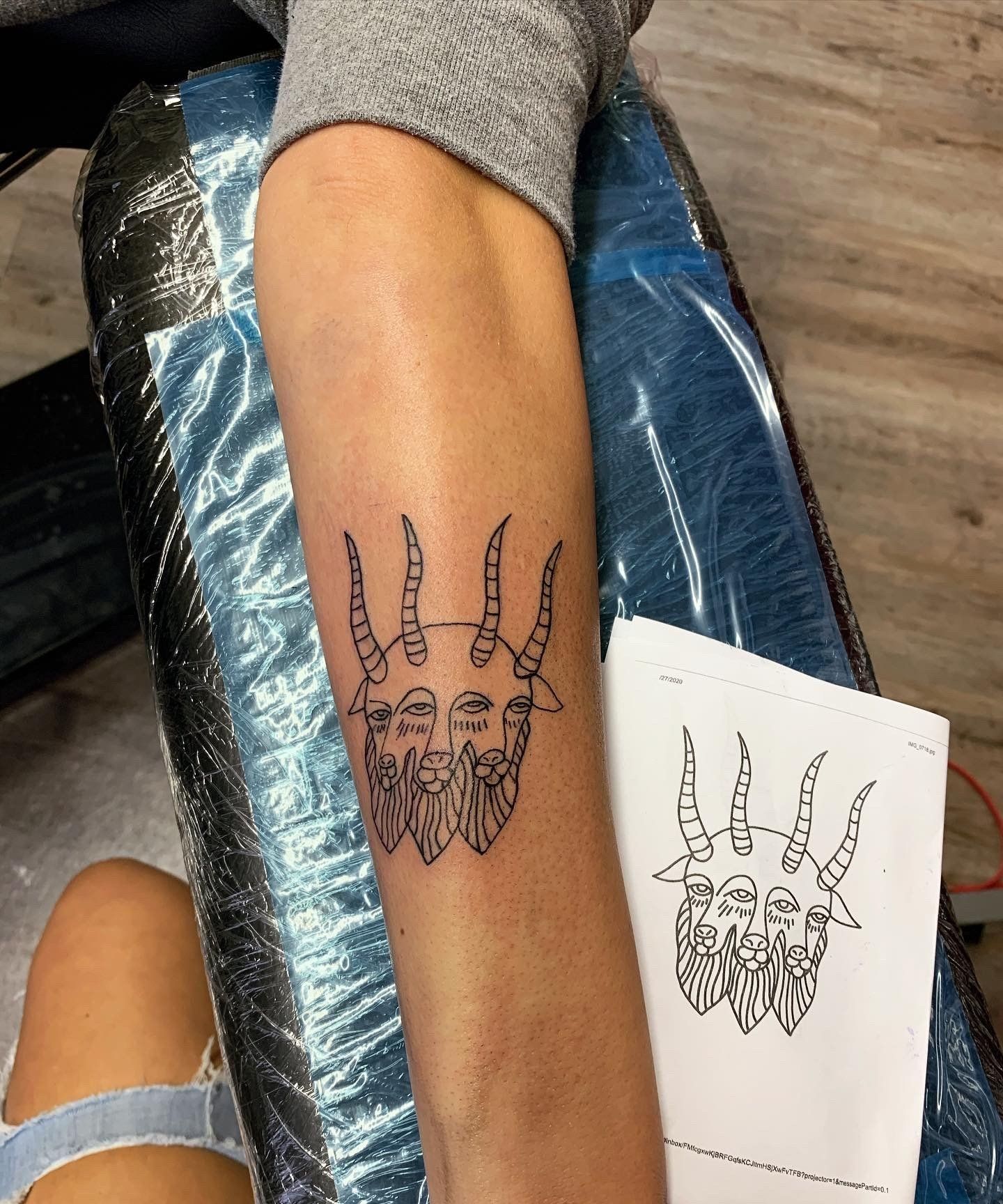 A person has a tattoo of a goat on their arm
