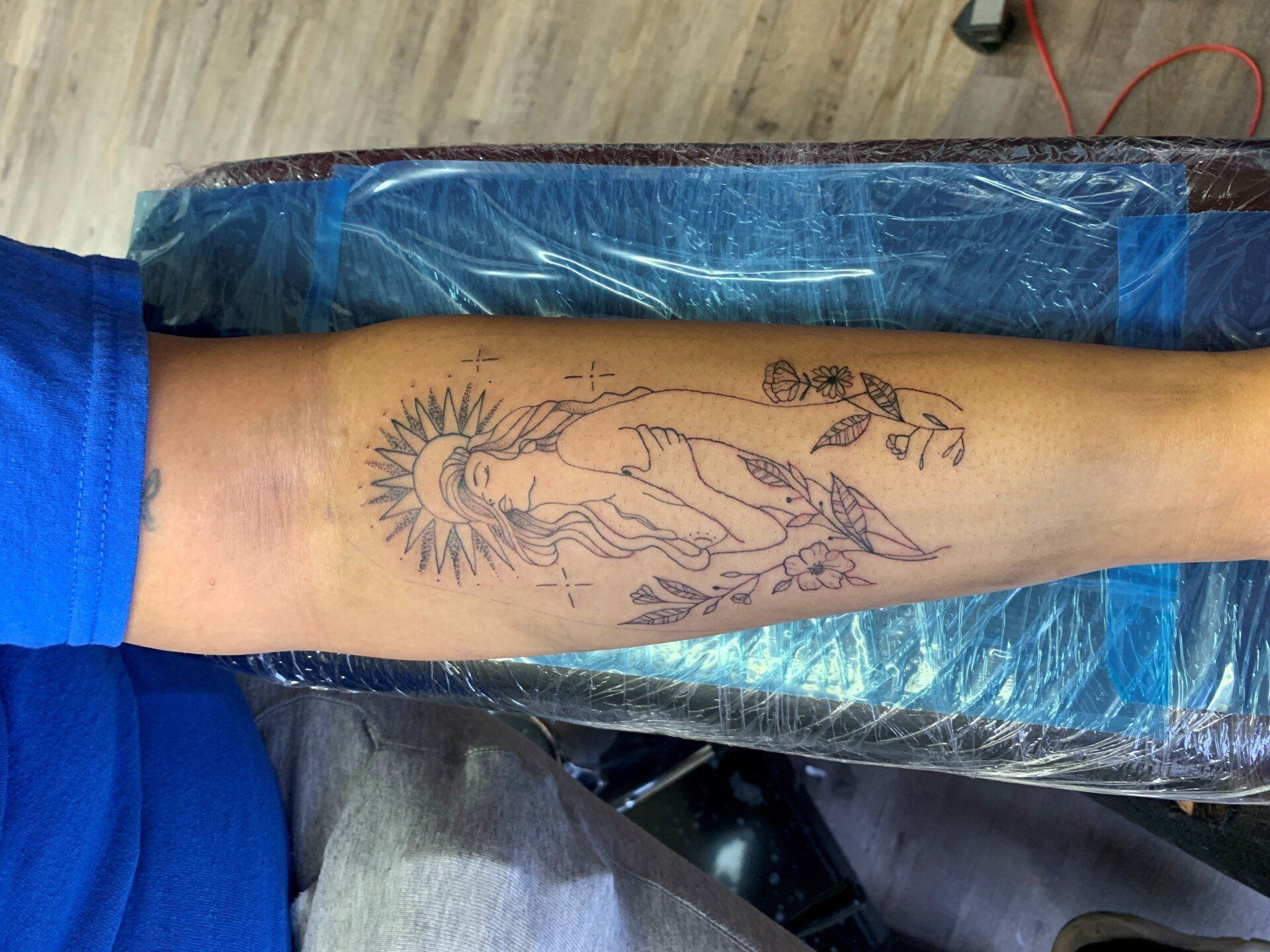 A person is getting a tattoo on their arm.