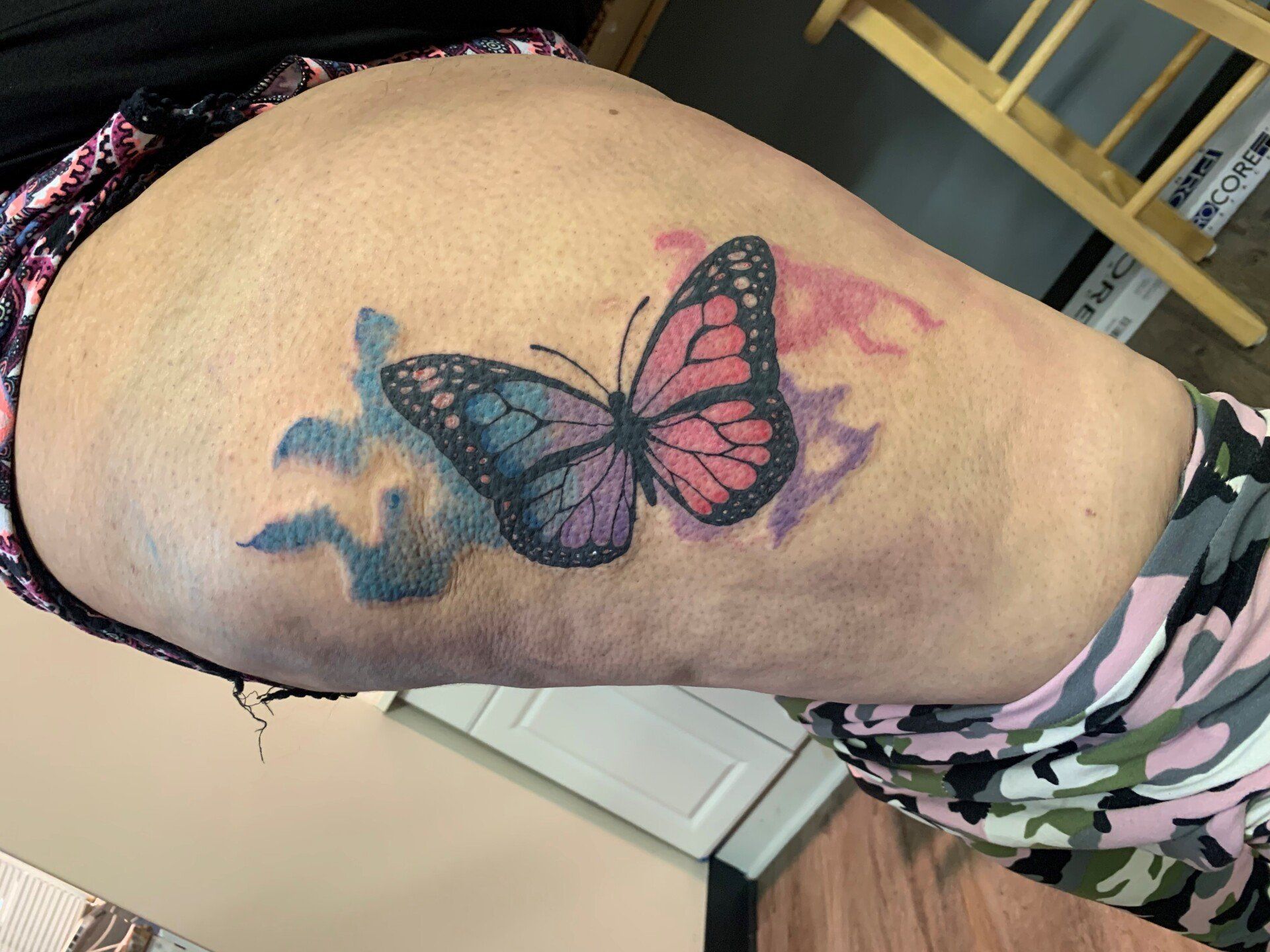 A woman has a tattoo of two butterflies on her thigh.