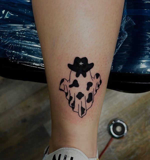 A person has a tattoo of a ghost on their leg
