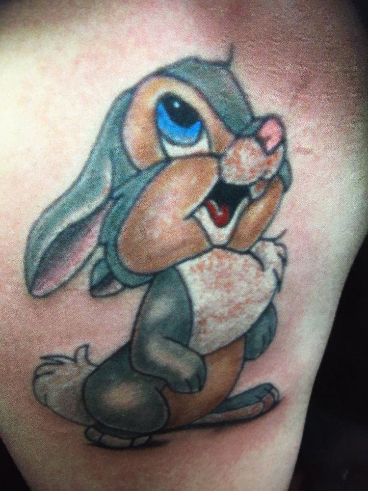 A close up of a tattoo of a rabbit on a person 's arm.