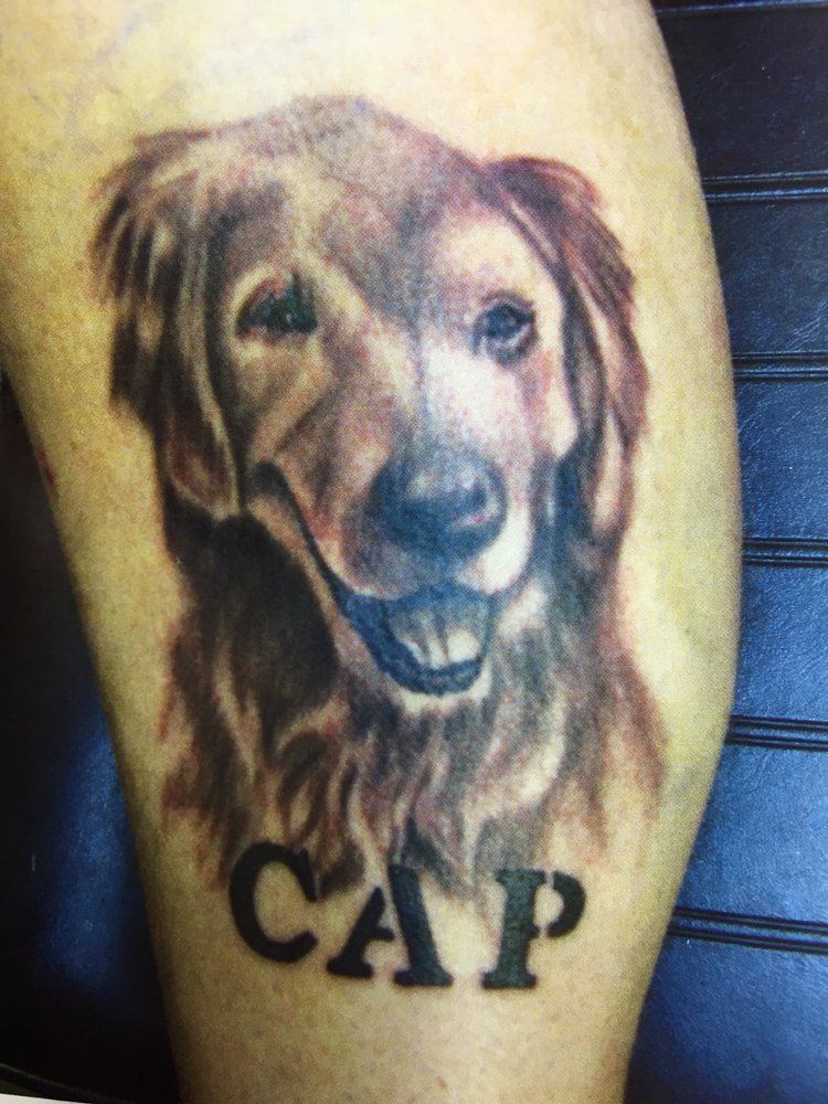 A tattoo of a dog with the name cap on it