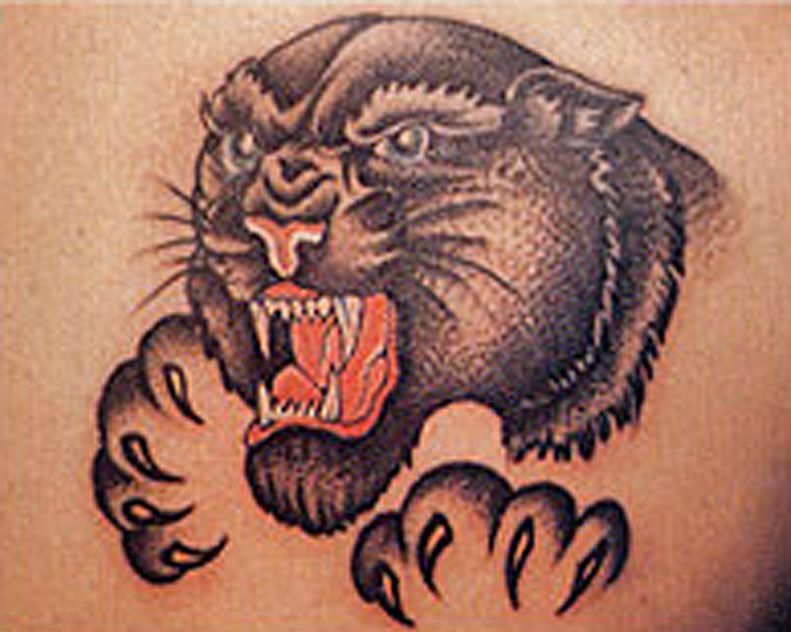 A close up of a black panther tattoo on a person 's back.