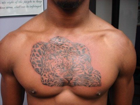 A man has a tattoo of a leopard on his chest.