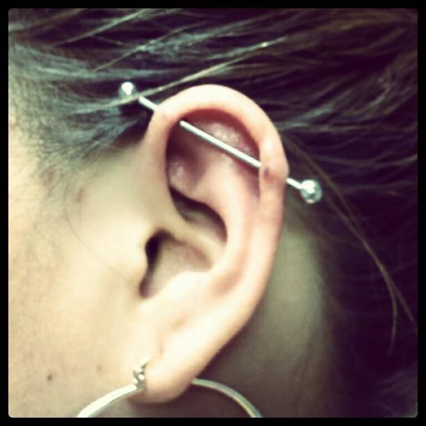 A close up of a woman 's ear with a piercing