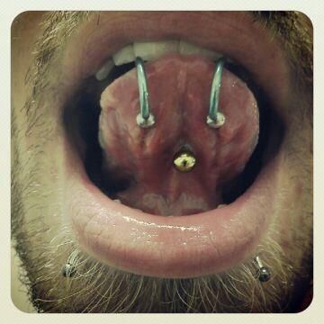 A close up of a person 's mouth with piercings