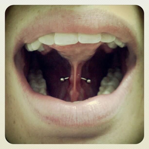 A close up of a person 's mouth with a tongue piercing