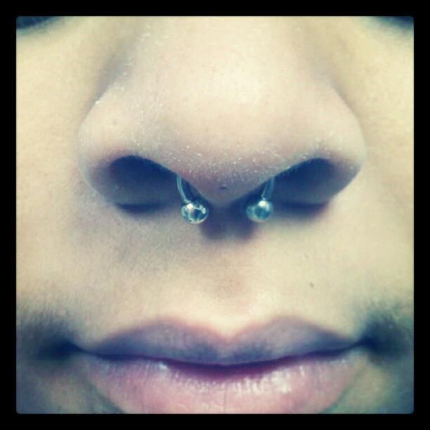 A close up of a person 's nose with a nose ring
