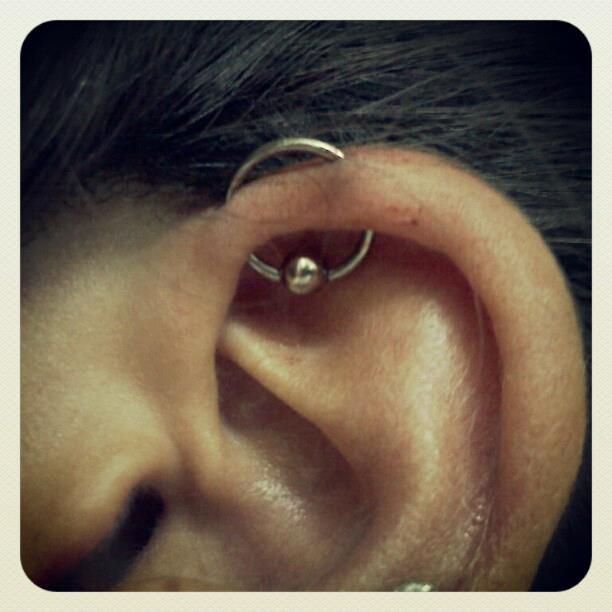A close up of a person 's ear with a piercing