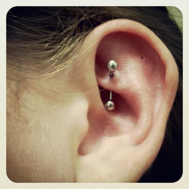 A close up of a person 's ear with two piercings