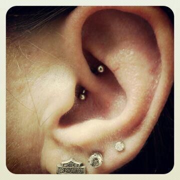 A close up of a woman 's ear with harley davidson earrings