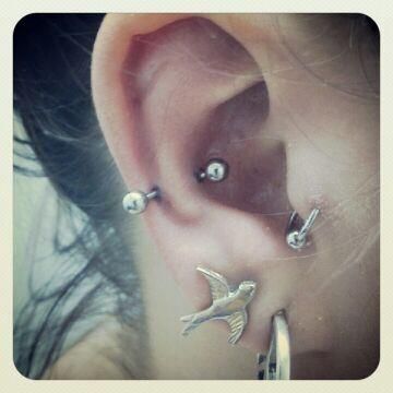 A close up of a woman 's ear with multiple piercings