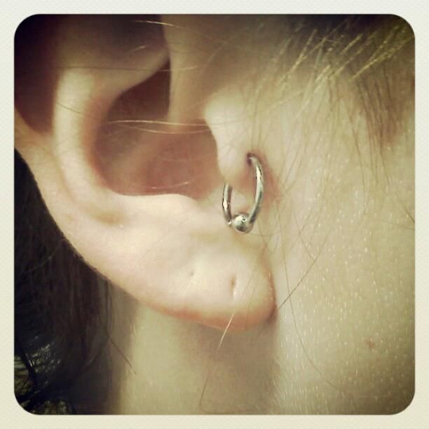 A close up of a woman 's ear with a ring in it