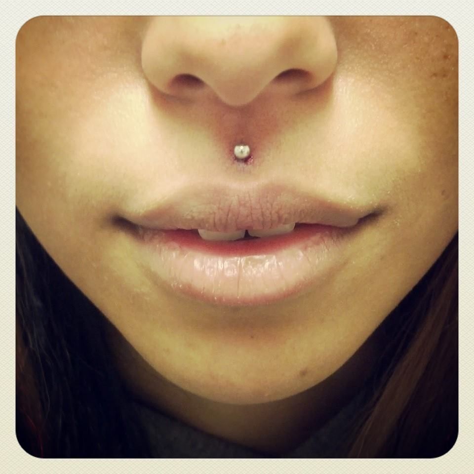 A close up of a woman 's face with a nose ring