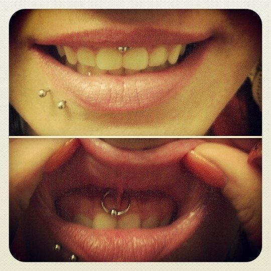 A close up of a woman 's mouth with piercings