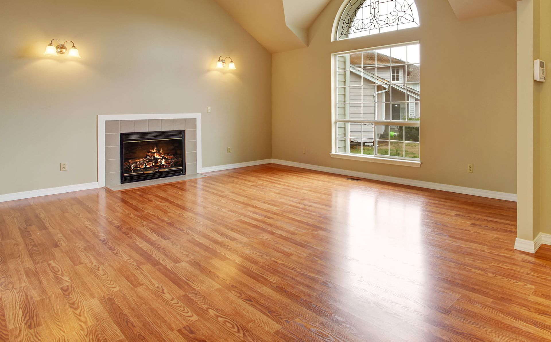 An empty living room with hardwood floors and a fireplace.