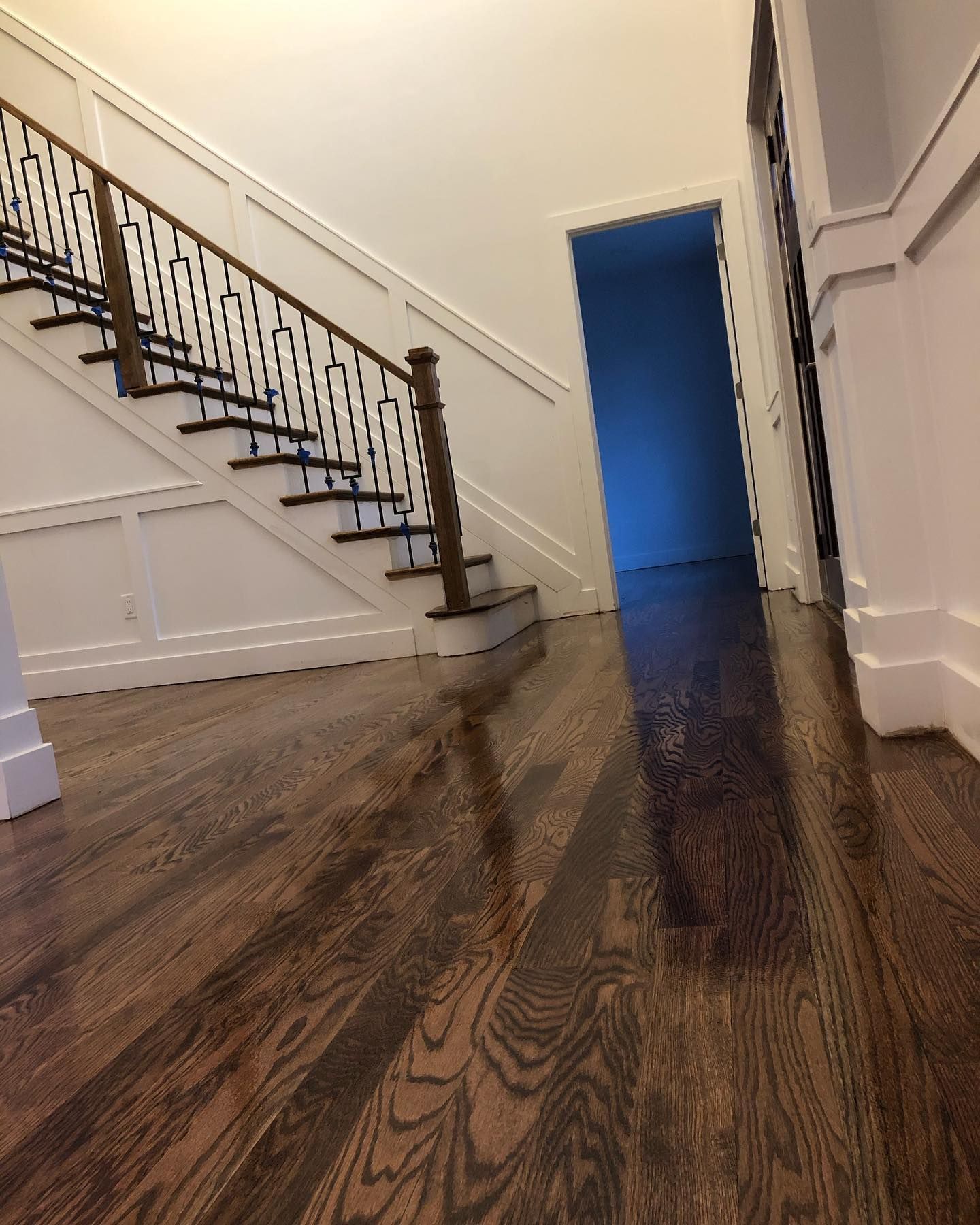A staircase with a wrought iron railing in a hallway