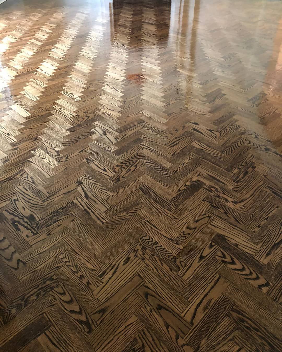 A close up of a wooden floor with a herringbone pattern.