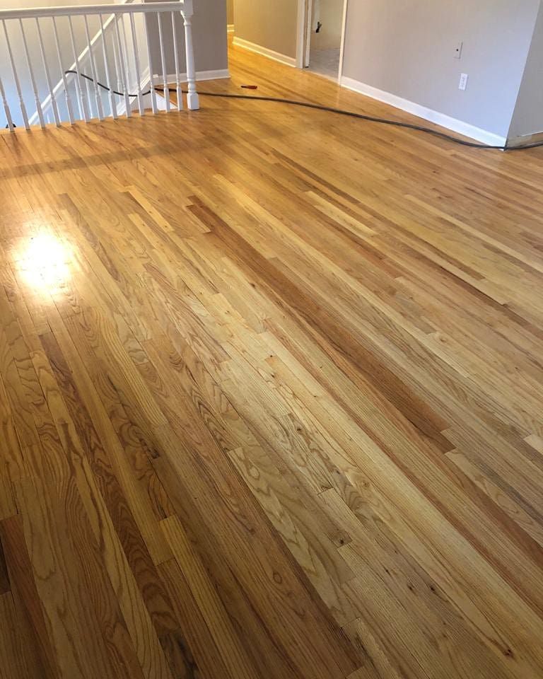 A living room with hardwood floors and stairs.