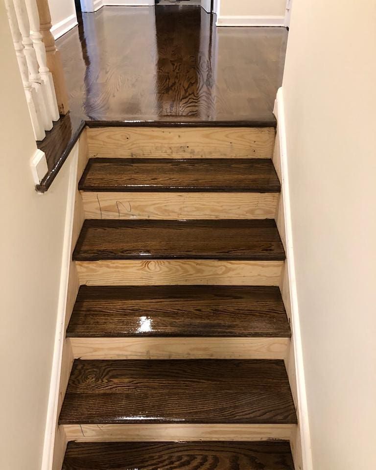 A set of wooden stairs leading up to a hallway in a house.