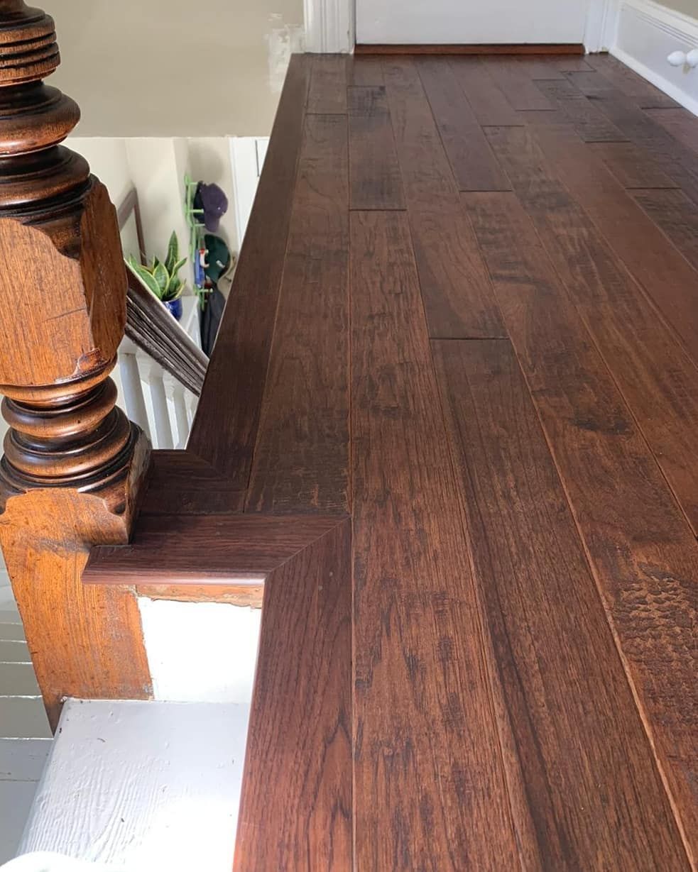 A wooden staircase with a wooden railing and a wooden floor.