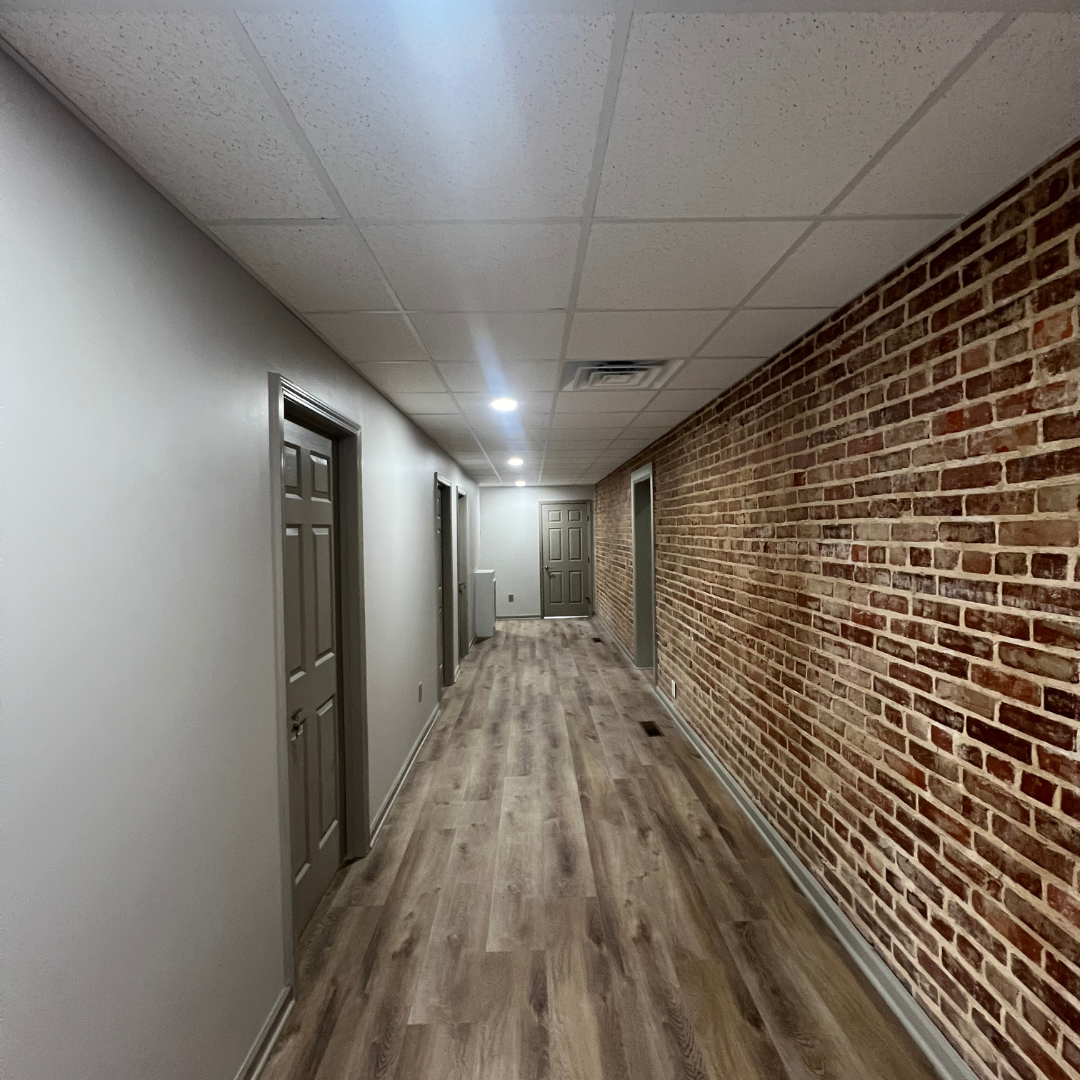 Kitchen with light speckled flooring and wooden cabinets.