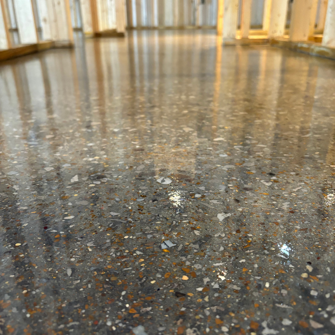 Bright, empty warehouse with white epoxy floor, metal beams, and a closed gray overhead door.