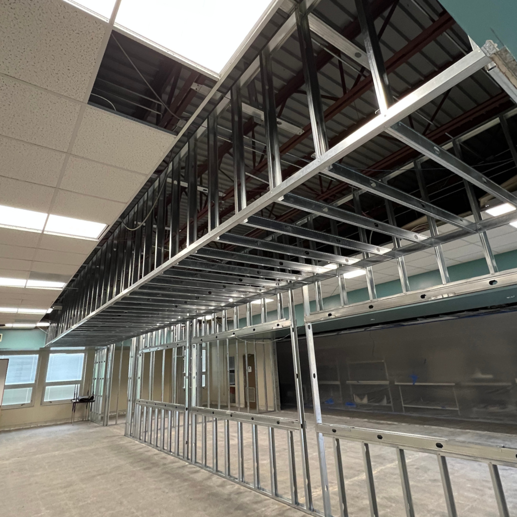 Steel framing for a suspended ceiling and interior walls in a large room.