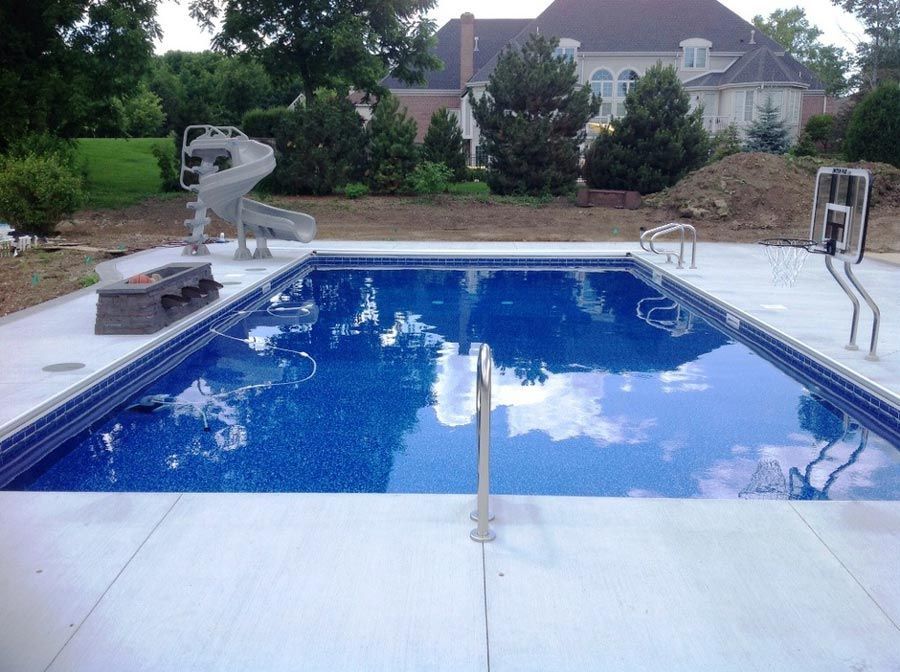 A large swimming pool with a slide in the backyard