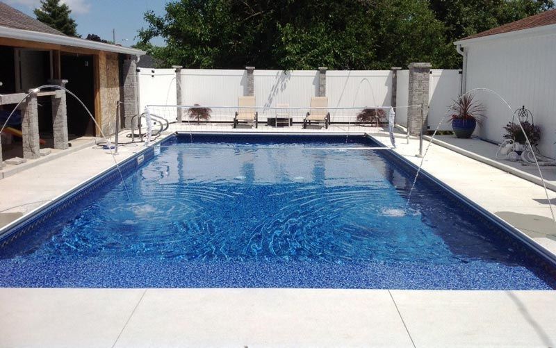 A large swimming pool with a white fence around it