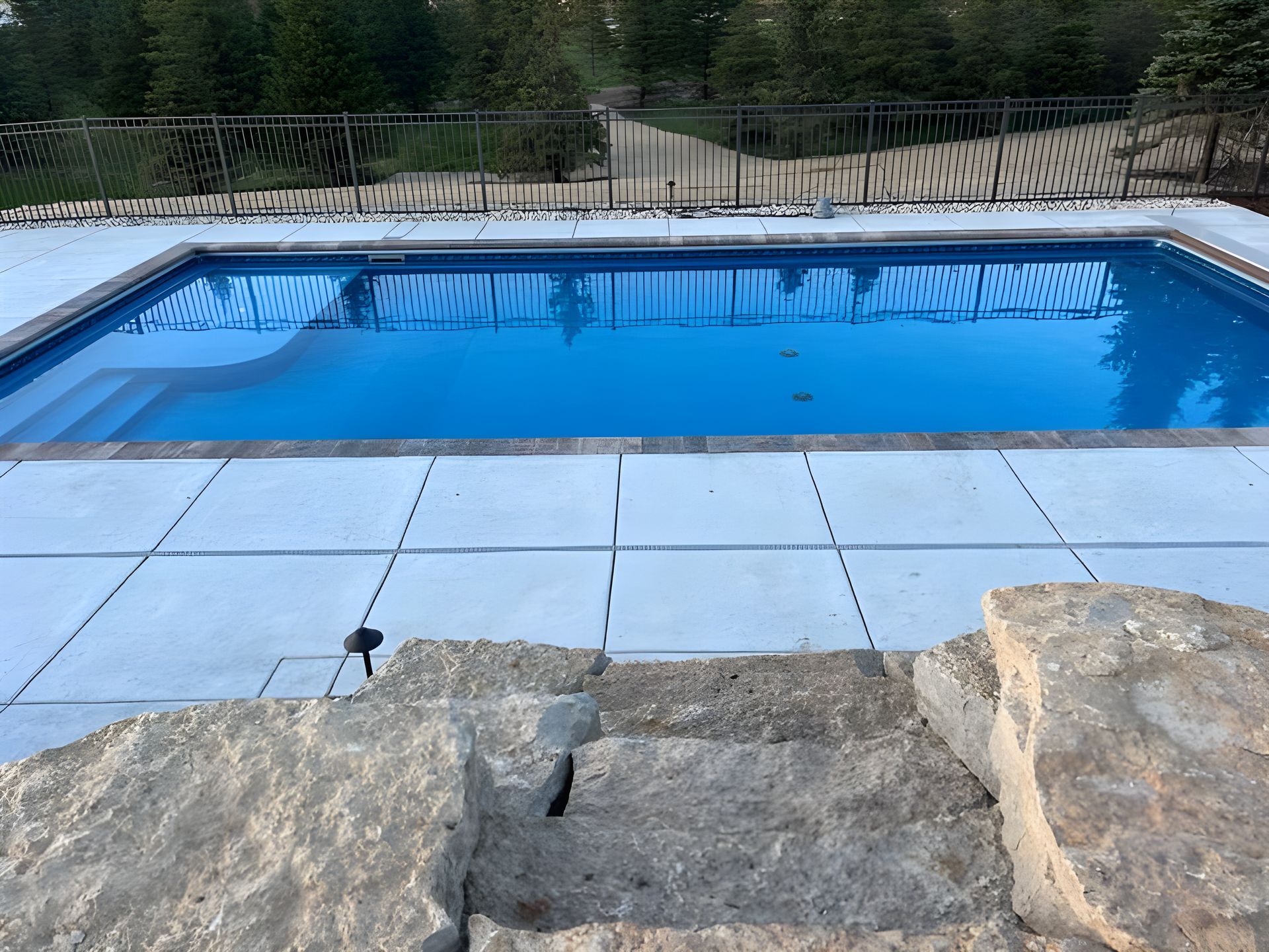 A large swimming pool with stairs leading to it