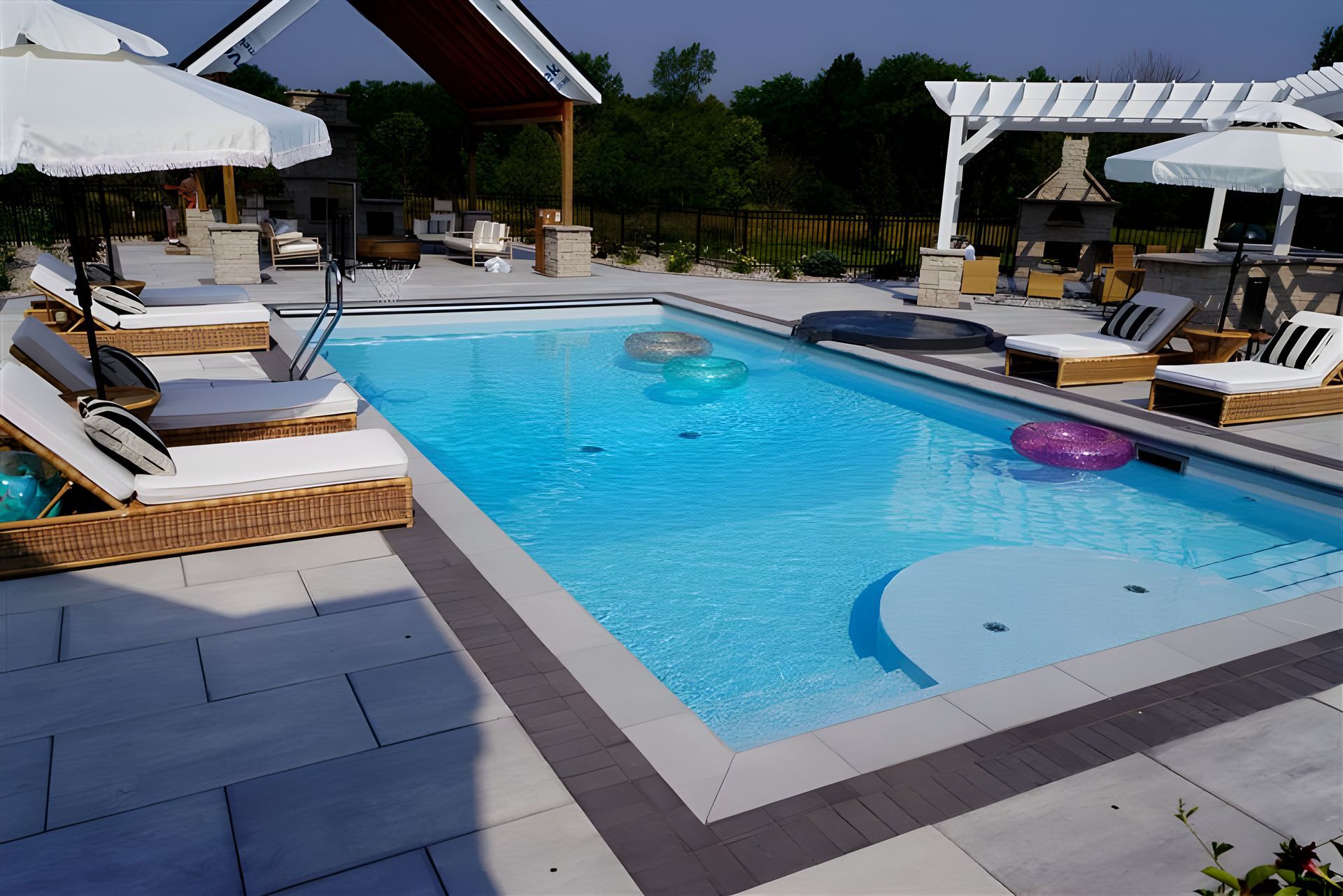 A large swimming pool surrounded by chairs and umbrellas