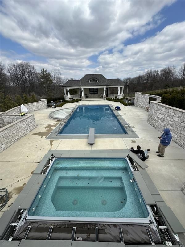 A large swimming pool is being built in front of a house.