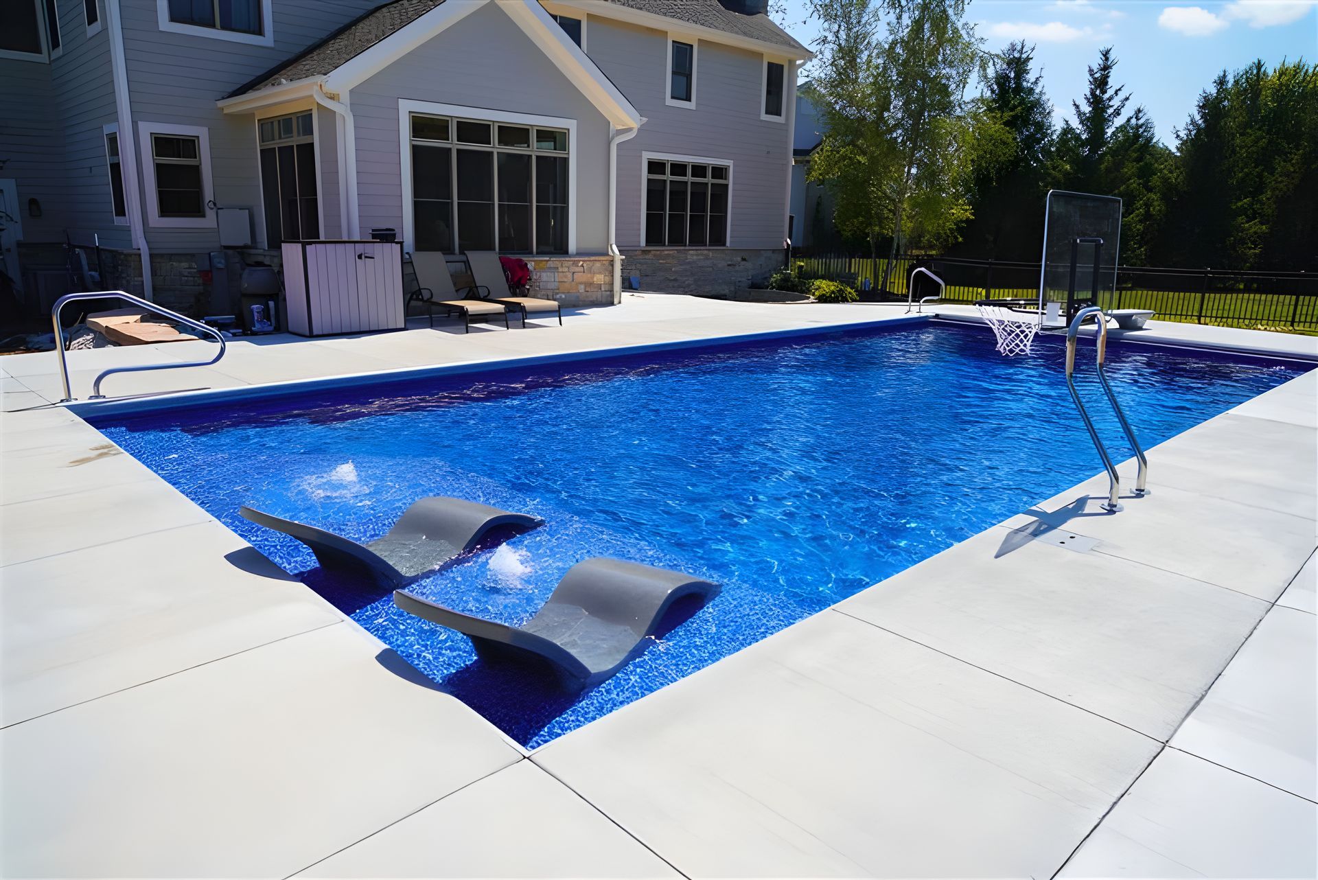 A large swimming pool with a house in the background