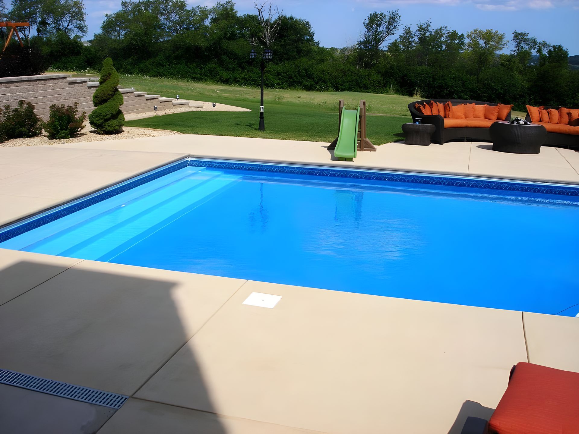 A large swimming pool with a slide in the backyard