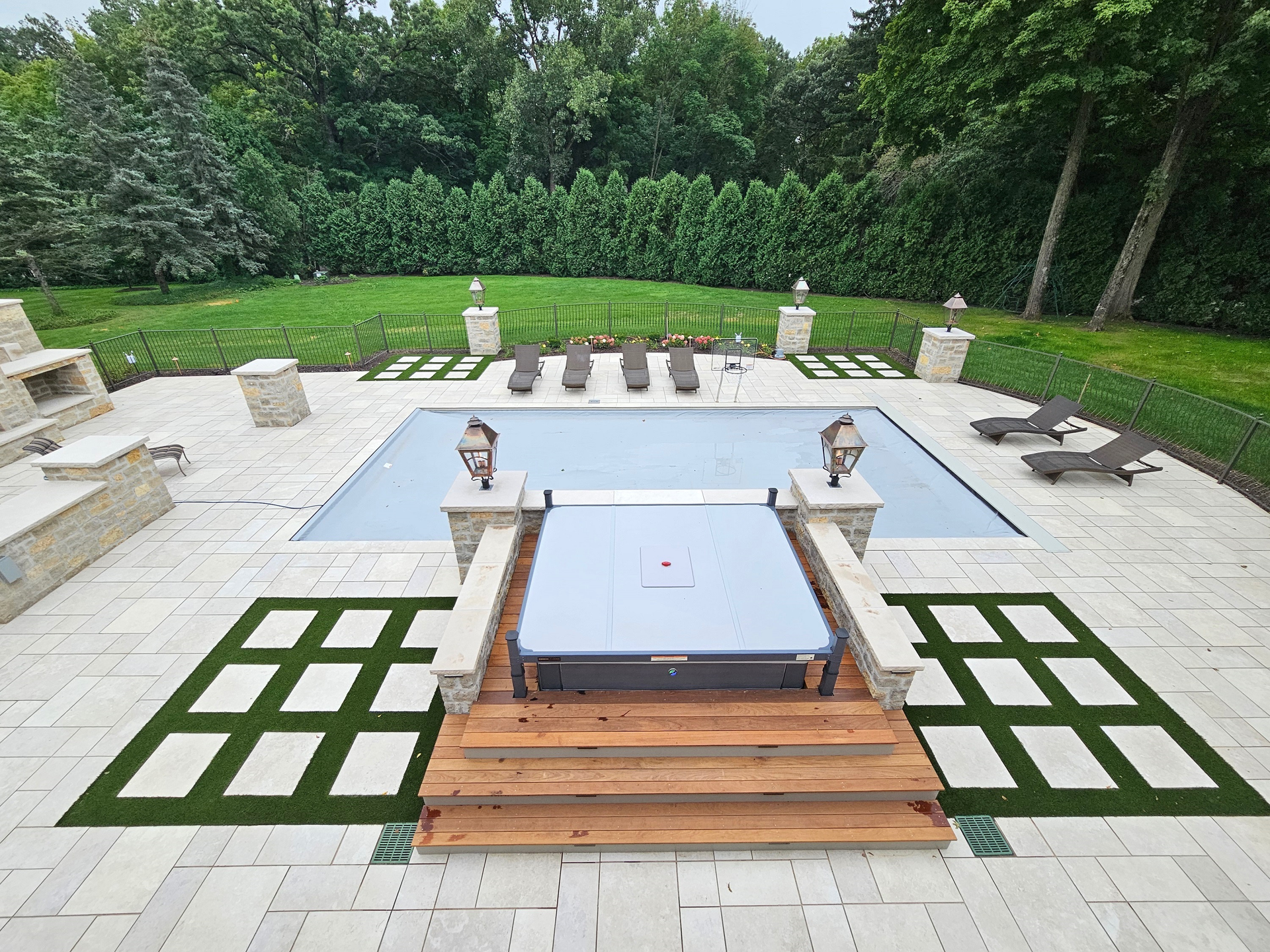 A large swimming pool with a hot tub in the middle of it