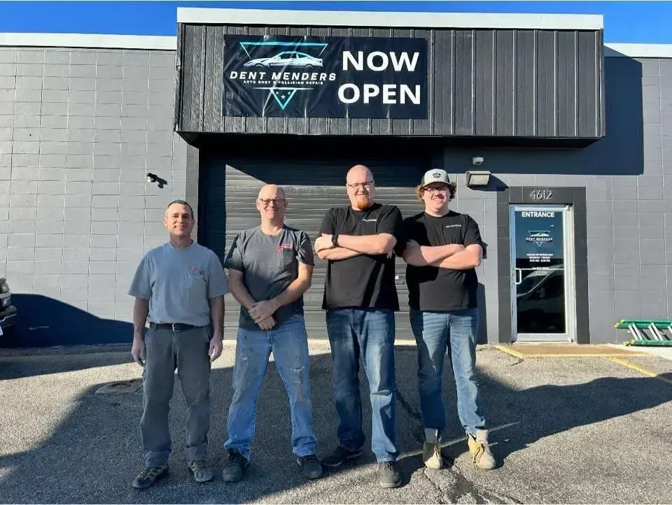 Four men stand outside 