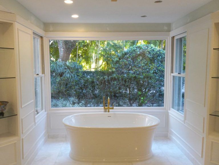 A bathroom with a large tub and a window.