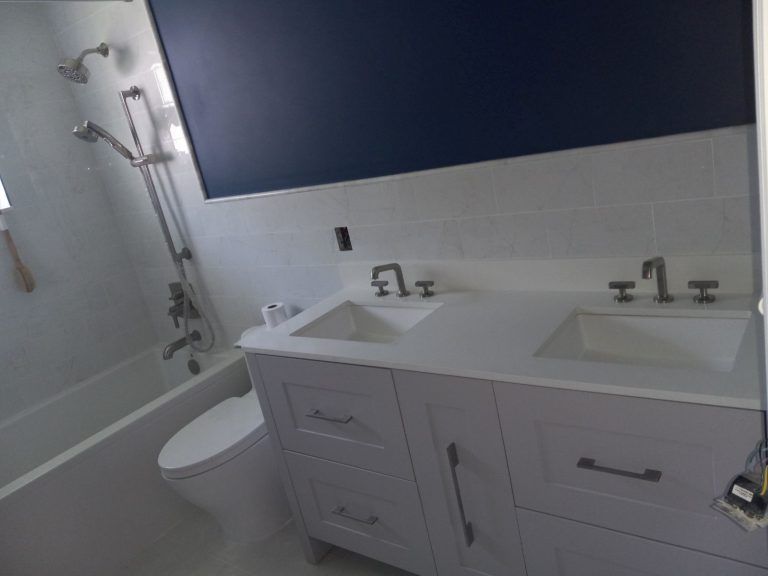 A bathroom with two sinks a toilet and a bathtub