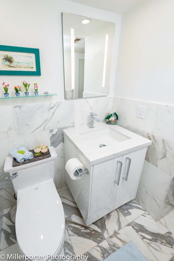 A bathroom with a toilet , sink and mirror