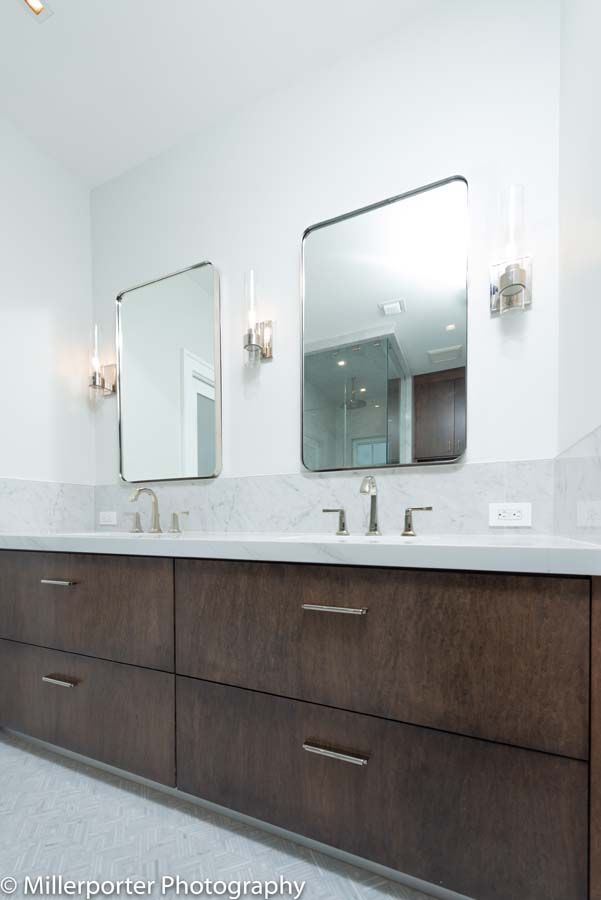 A bathroom with two sinks and two mirrors.