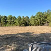 A atv is parked in a field with trees in the background.